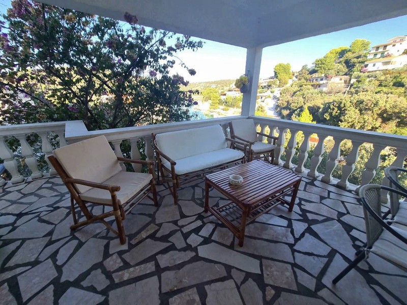 Terrasse couverte avec salon de jardin et vue sur la mer