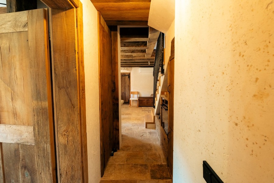 Couloir avec murs en pierre et portes en bois