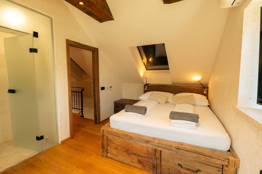 Chambre avec lit double et poutres en bois