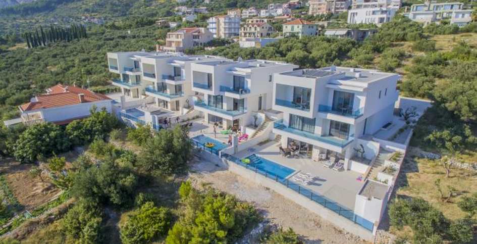 Vue aérienne de la rangée de maisons avec piscines sur la pente