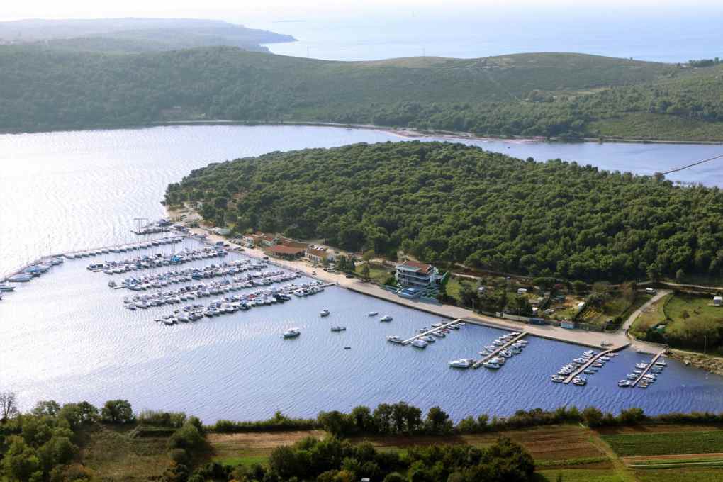 Vue aérienne de la marina avec pontons et presqu'île boisée