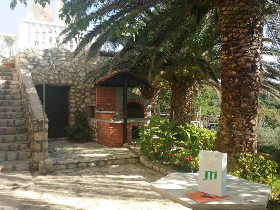 La cour de la villa d'appartements à vendre sur Pag est aménagée et plantée dans le style méditerranéen.
