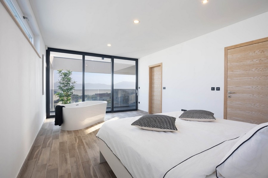 Chambre lumineuse avec baignoire îlot à la fenêtre